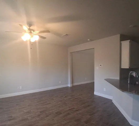 a view of a room with a sink and a chandelier fan