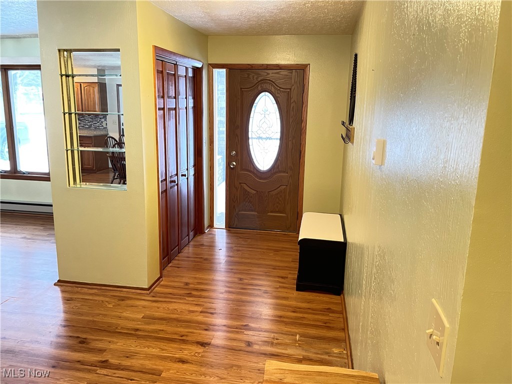 1381 Robb Road Conneaut, OH 44030 - Photo 6 of 50 Foyer featuring wood finished floors, a textured ceiling, and baseboard heating