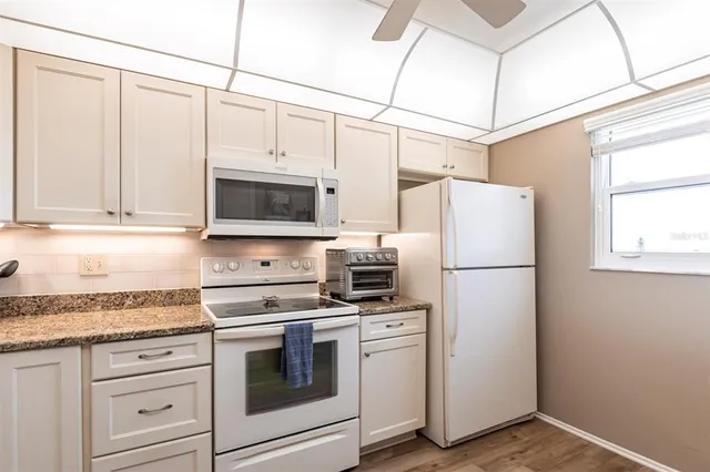 a kitchen with appliances a microwave and cabinets