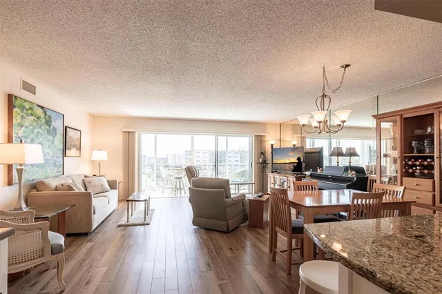 a living room with furniture large window and wooden floor