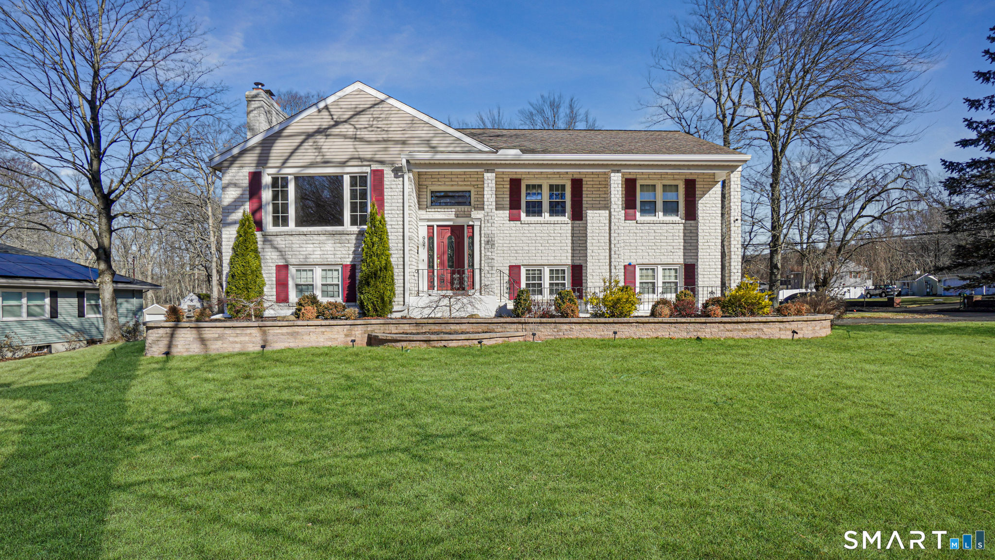 a view of a white house with a big yard and large trees