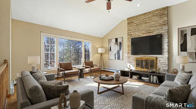 a living room with furniture a fireplace and a flat screen tv