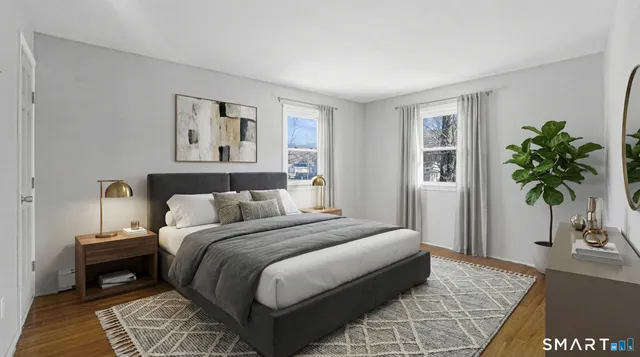 a bedroom with a large bed and a potted plant