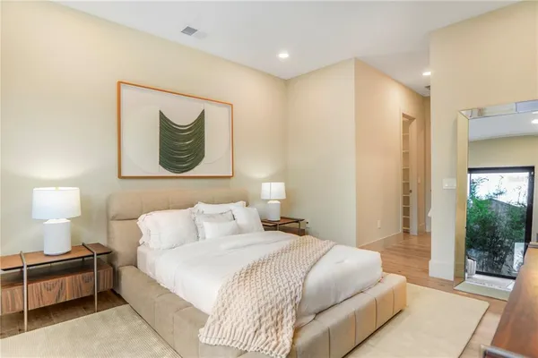 a bedroom with a large bed and a flat tv screen on dresser