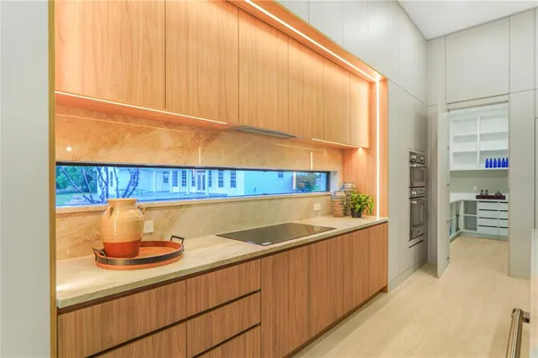 a kitchen with a sink and a stove with white cabinets