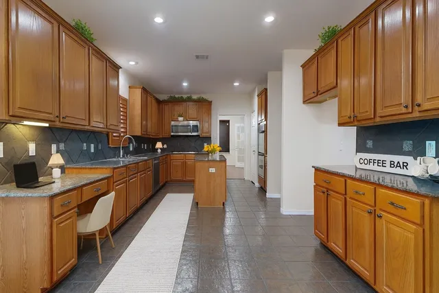 an empty room with wooden floor chandelier and windows