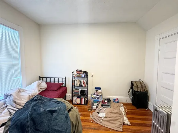 a bedroom with a bed and a wooden floor
