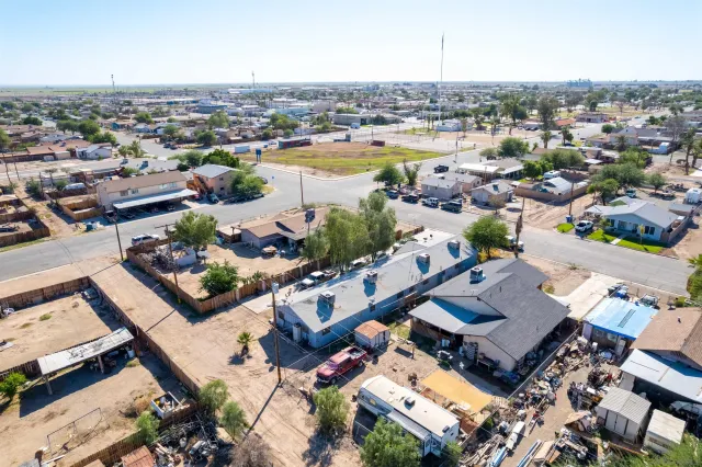 an aerial view of a city with lots of residential buildings and ocean view in back