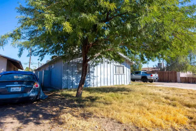 a view of a house with a large tree in the yard