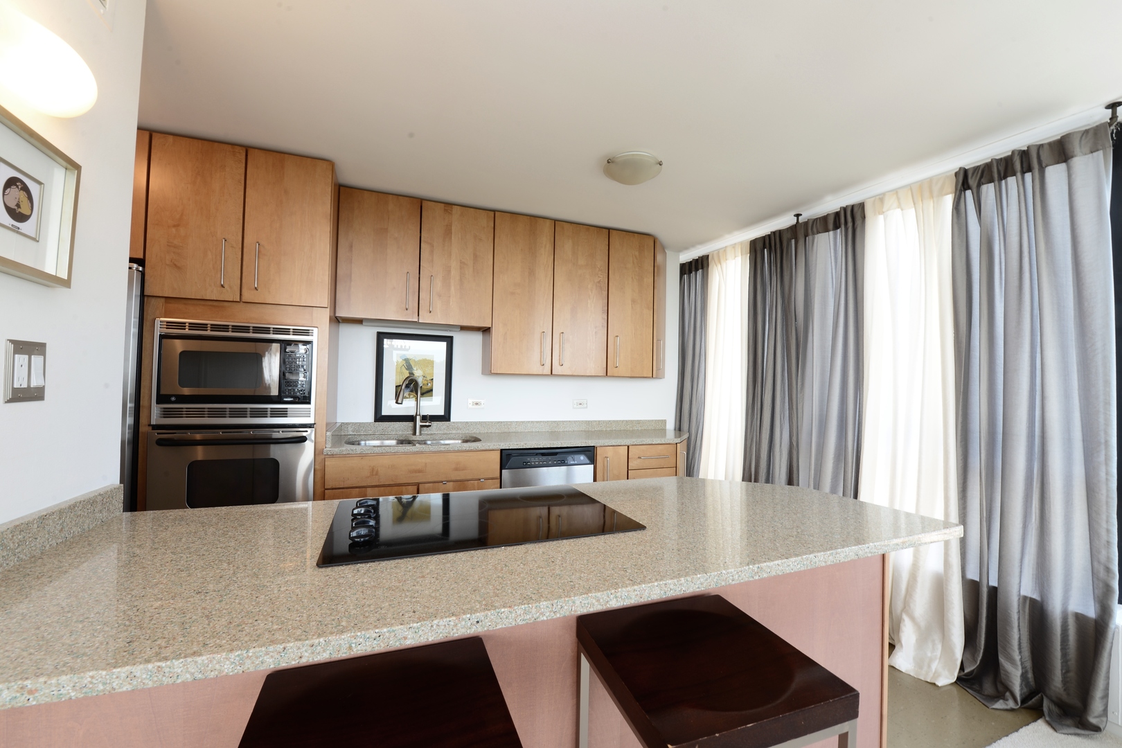 5415 North Sheridan Road, Unit 806 Chicago, IL 60640 - Photo 5 of 16 a kitchen with stainless steel appliances a stove a sink a microwave and cabinets