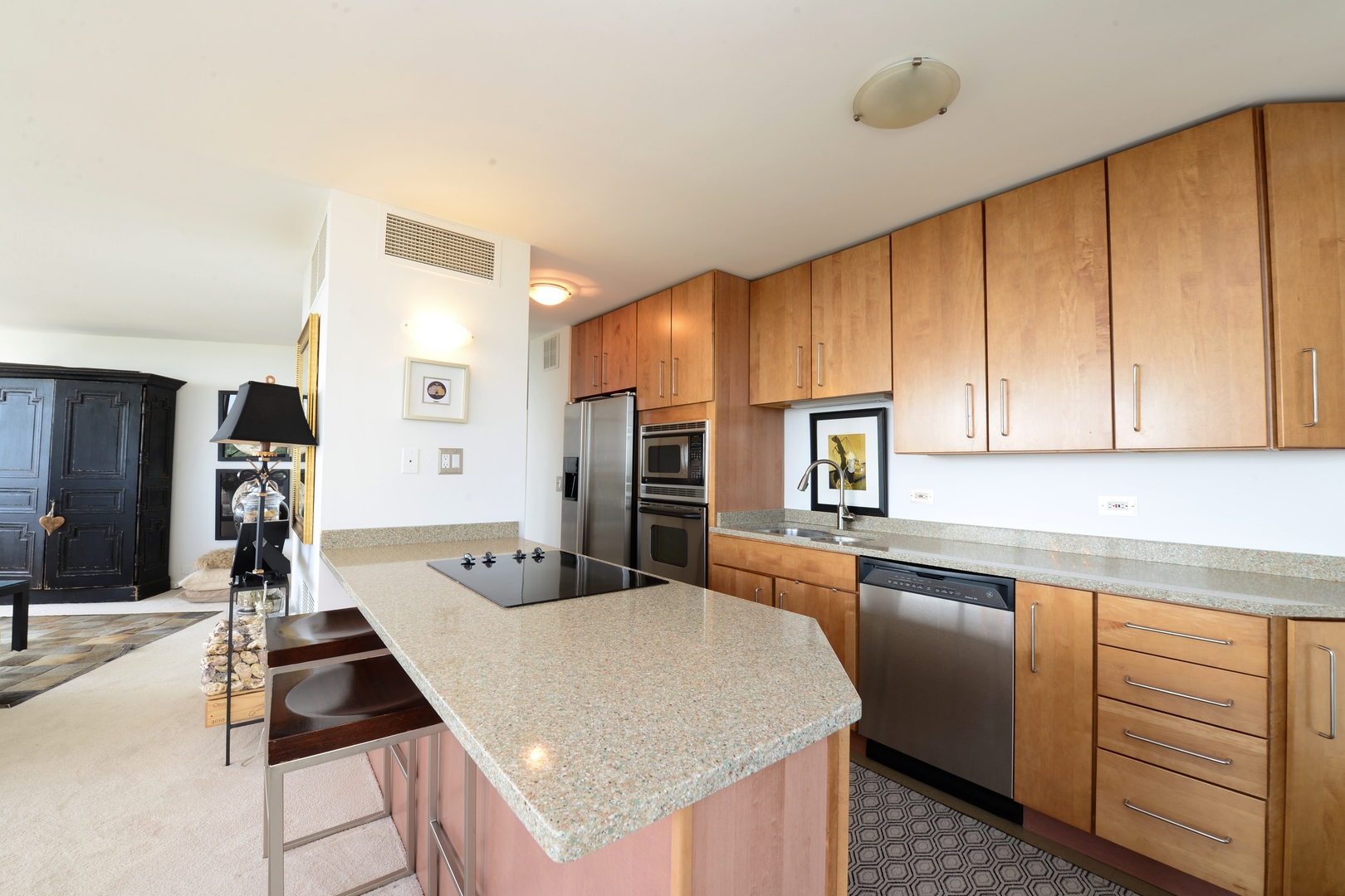 5415 North Sheridan Road, Unit 806 Chicago, IL 60640 - Photo 6 of 16 a kitchen with kitchen island granite countertop a sink stove and refrigerator