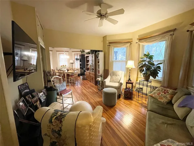 a living room with furniture a chandelier and a flat screen tv