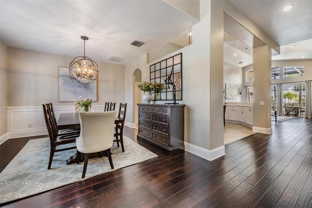 2730 Manning Drive Trinity, FL 34655 - Photo 15 of 43 a dining room with furniture a chandelier and wooden floor