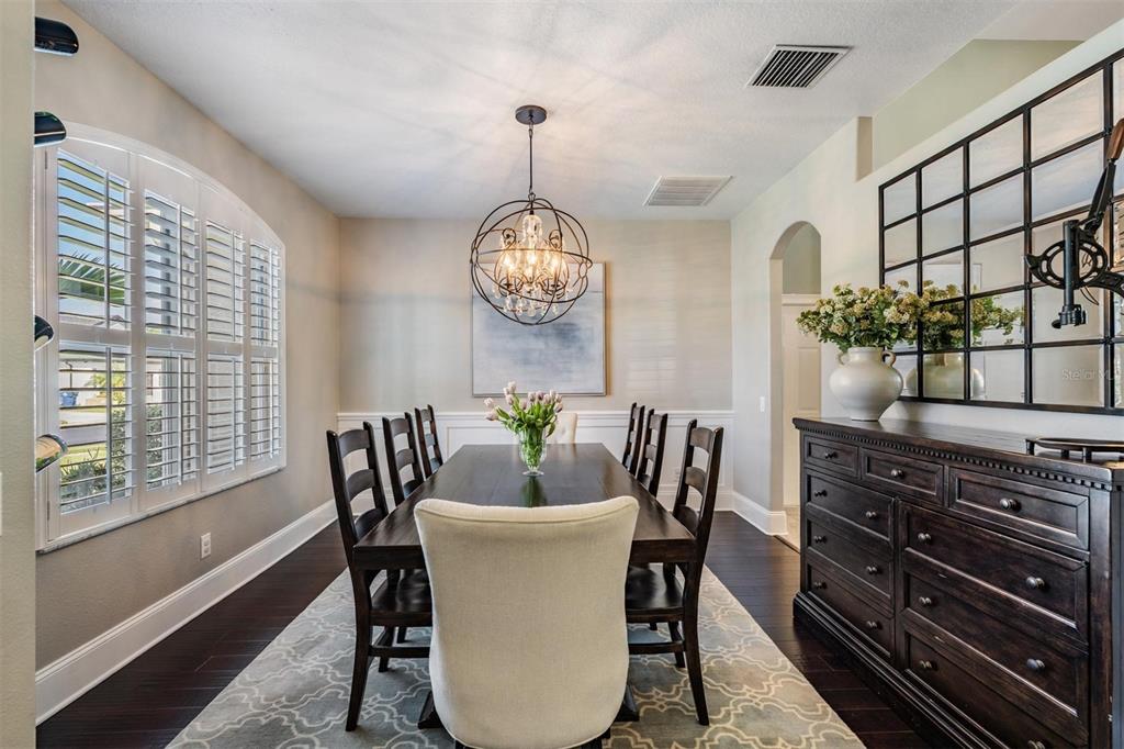 2730 Manning Drive Trinity, FL 34655 - Photo 16 of 43 a dining room with furniture a potted plant and wooden floor
