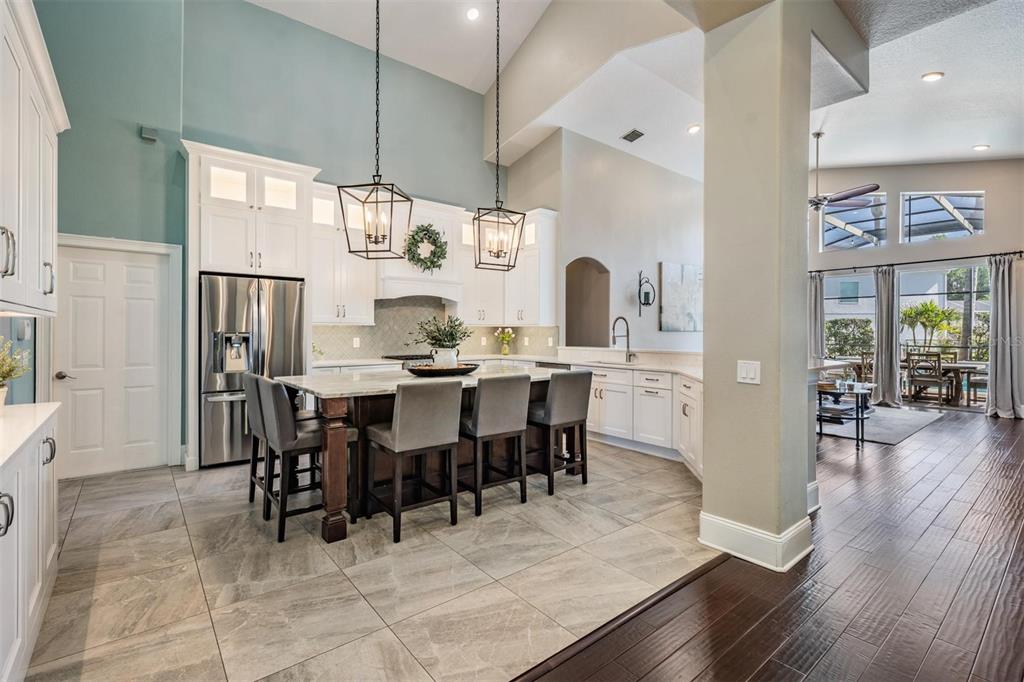 2730 Manning Drive Trinity, FL 34655 - Photo 9 of 43 a dining room with stainless steel appliances kitchen island granite countertop a table chairs and a refrigerator