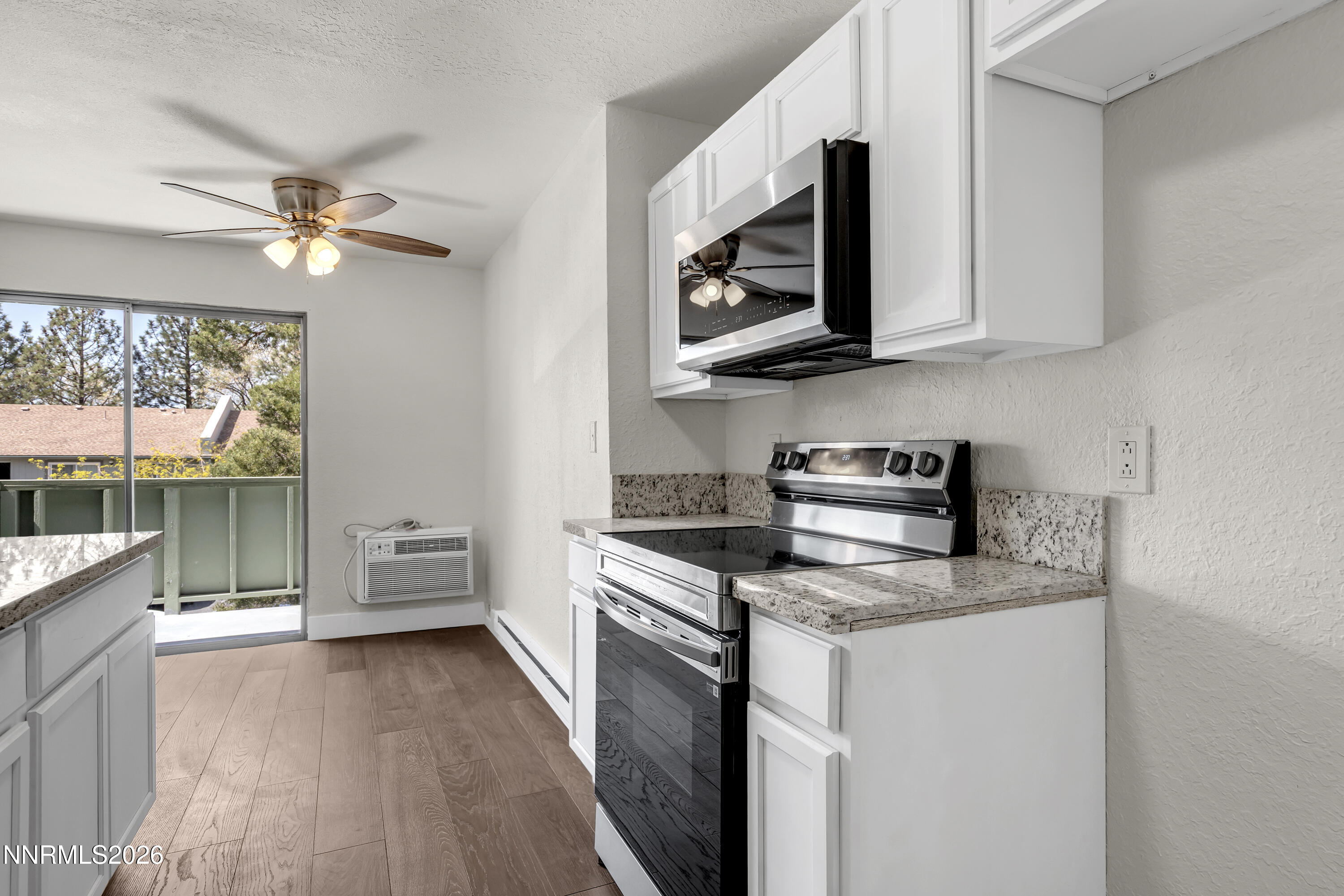 3905 Clear Acre Lane, Unit 26 Reno, NV 89512 - Photo 4 of 27 a kitchen with stainless steel appliances a stove a microwave and white cabinets