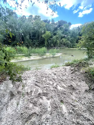 a view of a green field with a tree
