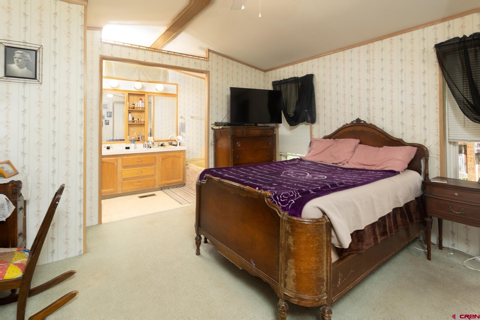 875 Browning Avenue Ignacio, CO 81137 - Photo 16 of 24 a spacious bedroom with a bed and a flat screen tv