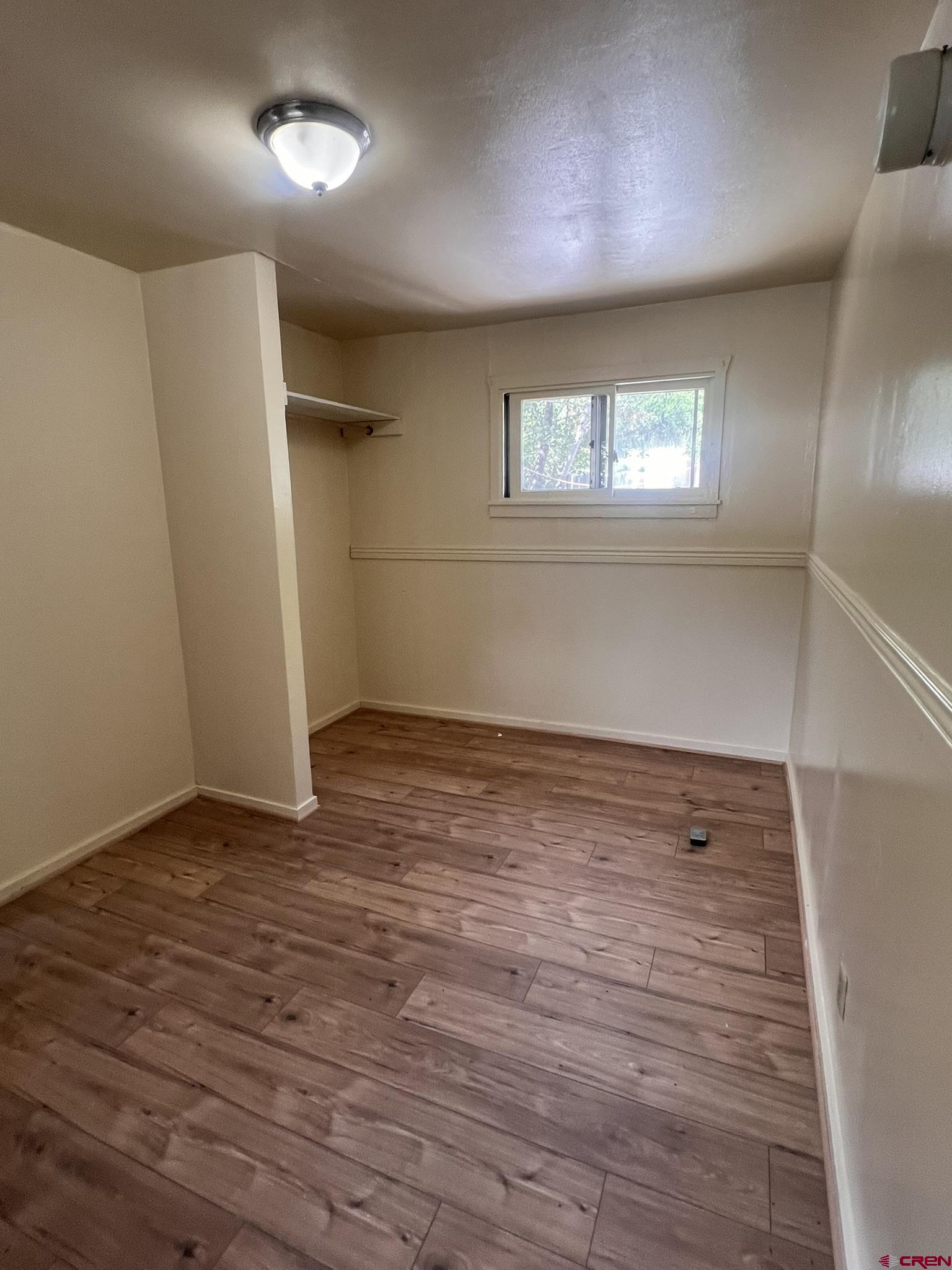 875 Browning Avenue Ignacio, CO 81137 - Photo 10 of 24 an empty room with wooden floor and windows