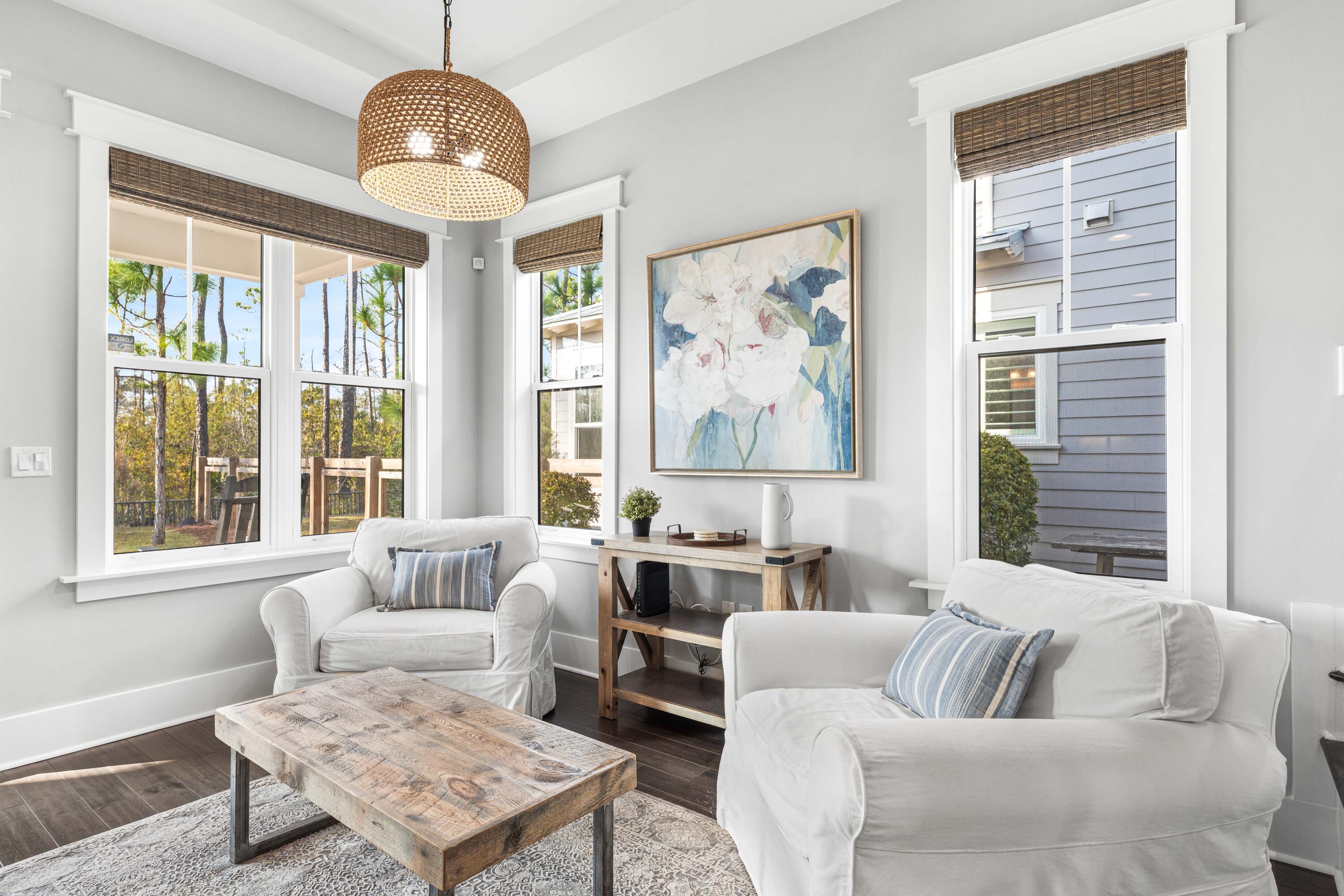 1085 Sandgrass Boulevard Santa Rosa Beach, FL 32459 - Photo 20 of 62 a living room with furniture a large window and a chandelier