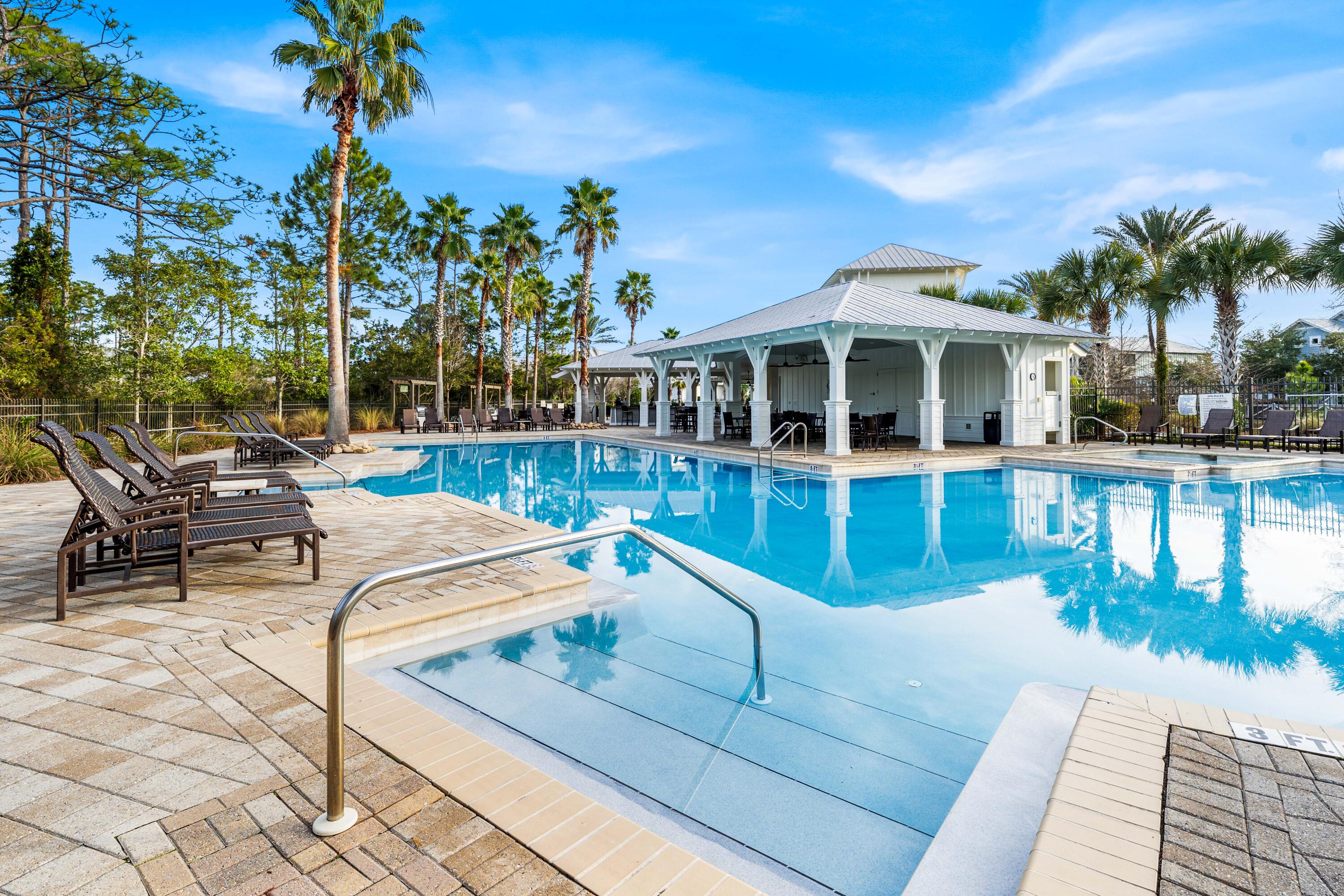 1085 Sandgrass Boulevard Santa Rosa Beach, FL 32459 - Photo 59 of 62 a view of a patio with couches table and chairs potted plants and palm tree