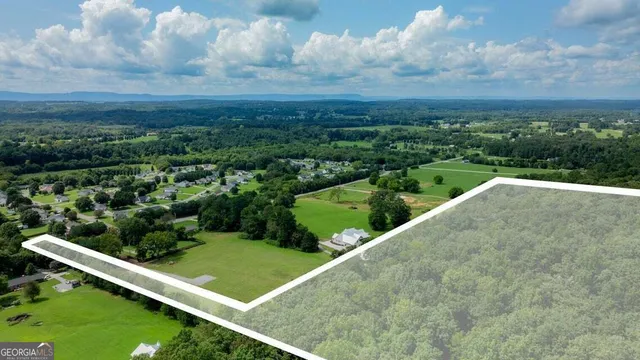 a view of a green field with wooden fence