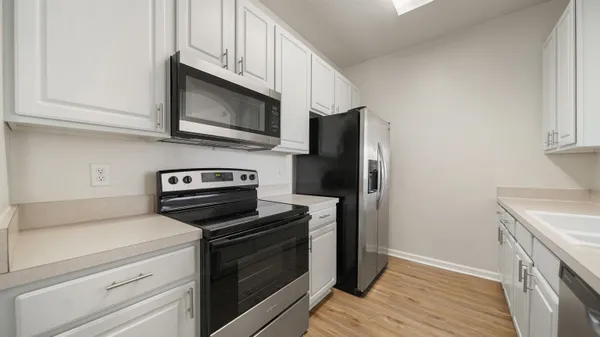 a kitchen with stainless steel appliances a stove microwave and refrigerator