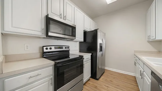 a kitchen with stainless steel appliances a stove microwave and refrigerator