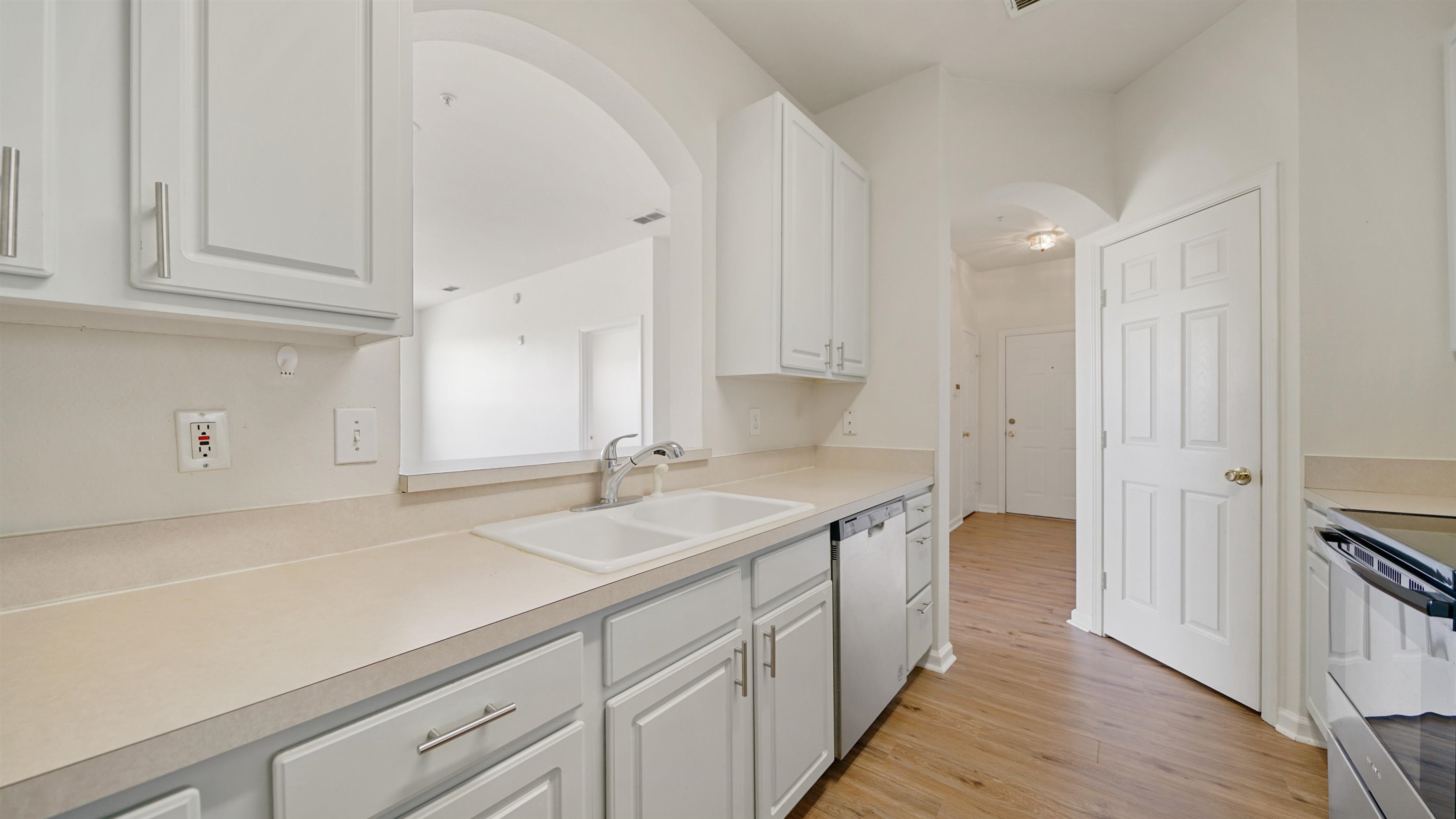 7990 Baymeadows Road, Unit 1114 Jacksonville, FL 32256 - Photo 6 of 30 a kitchen with a sink dishwasher and cabinets with wooden floor