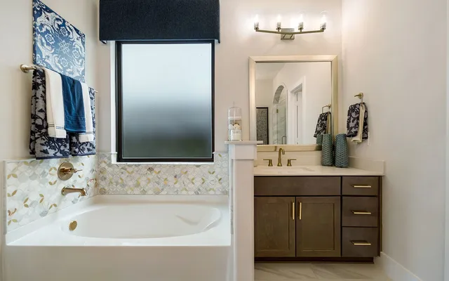 a bathroom with a bathtub sink and mirror