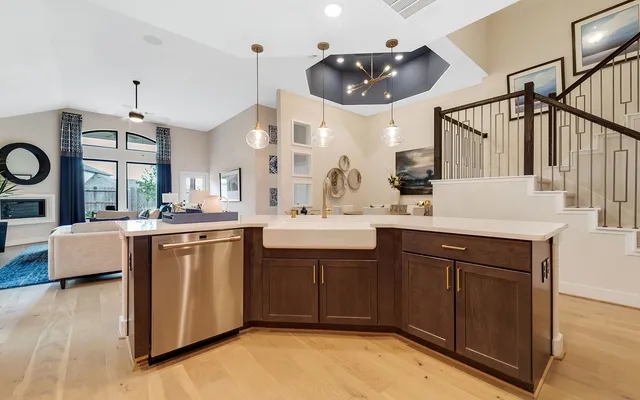 a kitchen with kitchen island granite countertop a sink a counter space and stainless steel appliances