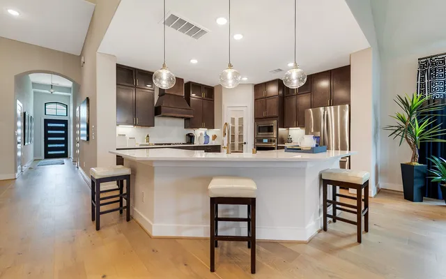 a kitchen with kitchen island a counter top space a sink stainless steel appliances and cabinets