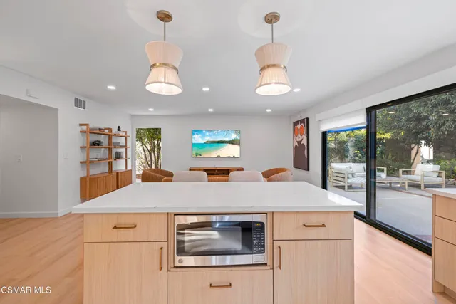 a kitchen with kitchen island a counter top a stove and a chandelier