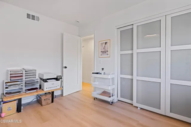 a view of a workspace with furniture and wooden floor