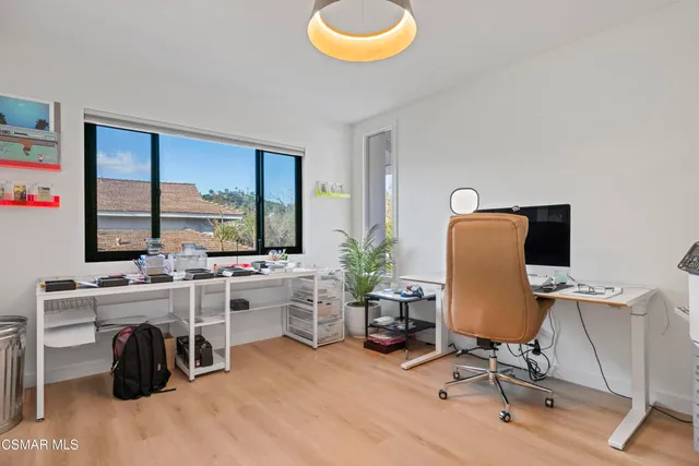 a view of a workspace with furniture and a window