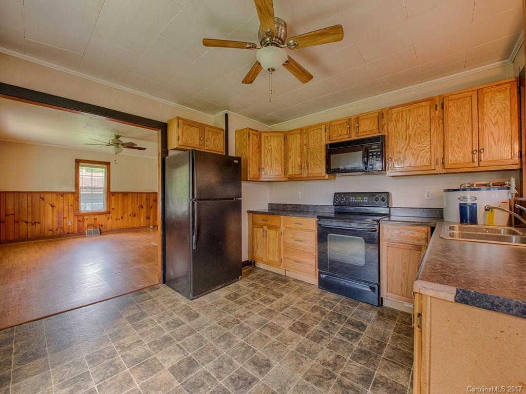 277 Chelsea Road Waynesville, NC 28786 - Photo 13 of 18 a kitchen with granite countertop a refrigerator a stove a sink a oven with a dining table and chairs