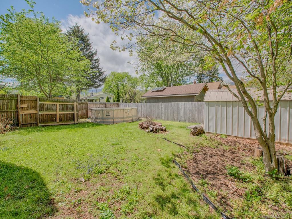 277 Chelsea Road Waynesville, NC 28786 - Photo 5 of 18 a view of a backyard with table and chairs and wooden fence