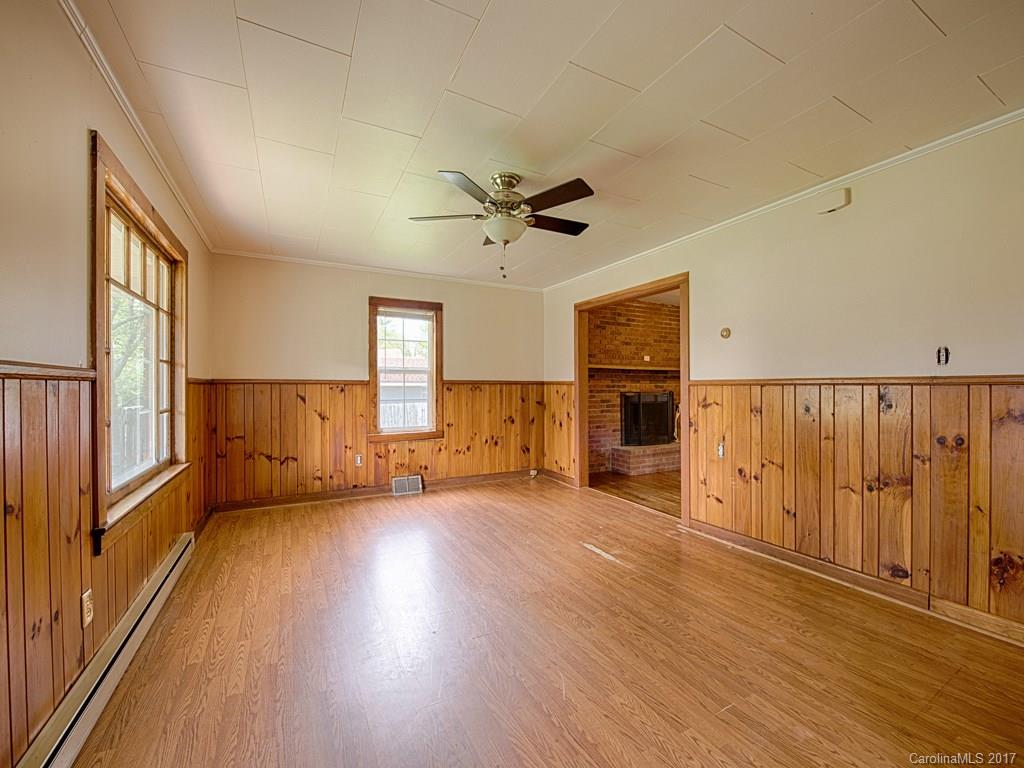 277 Chelsea Road Waynesville, NC 28786 - Photo 9 of 18 wooden floor in an empty room with a window and a kitchen