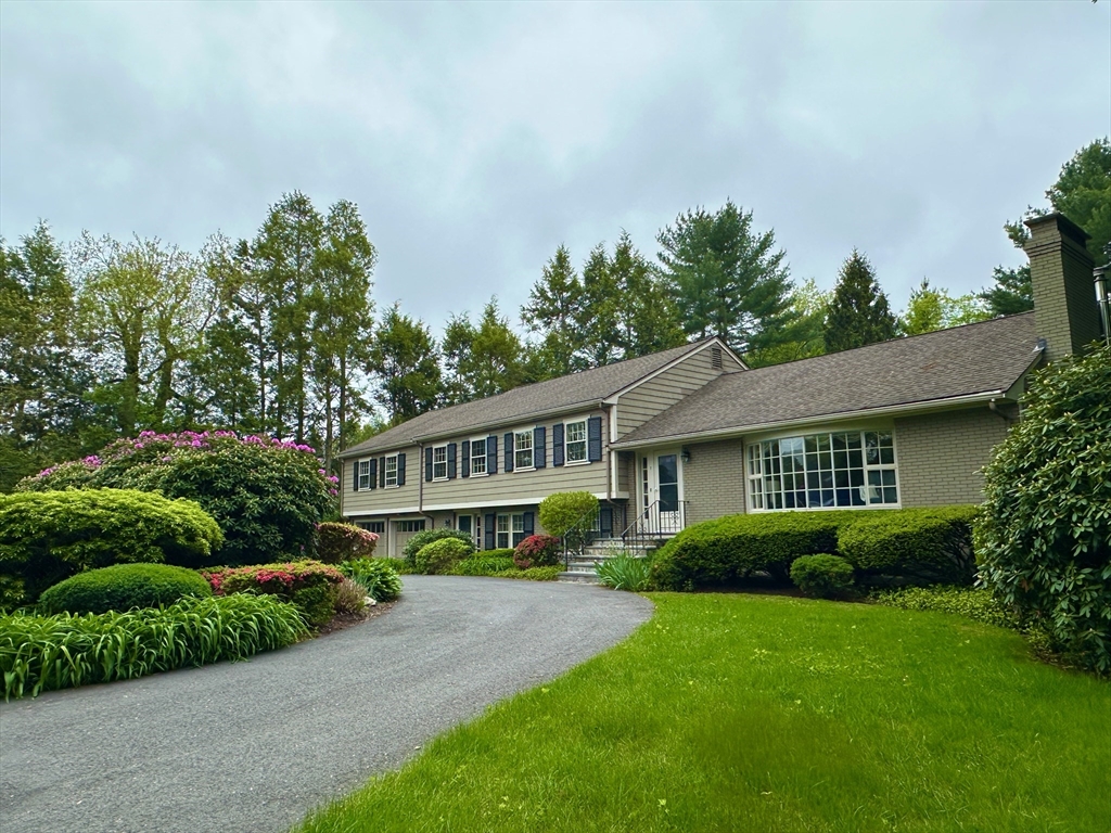 a house with green field in front of it