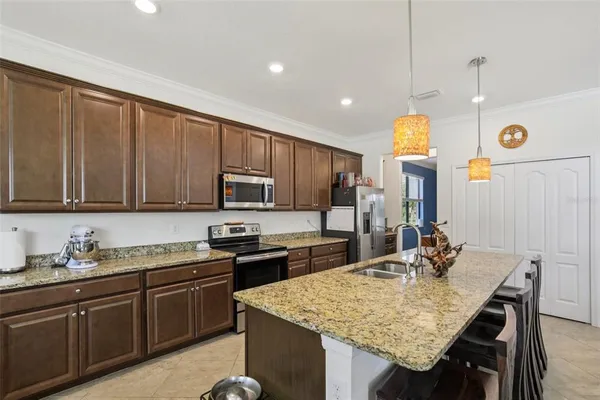 a kitchen with a sink a stove and chairs