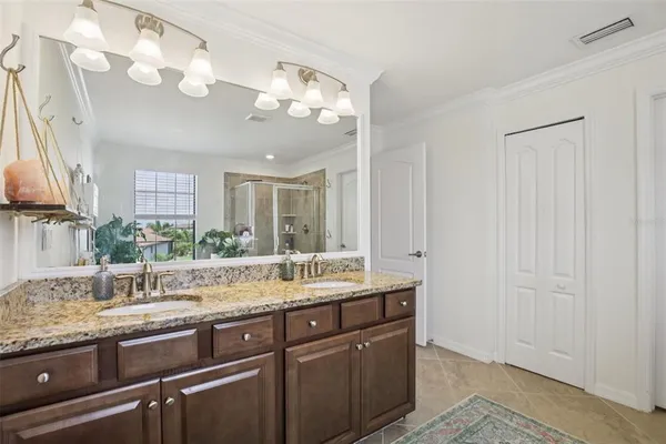 a bathroom with a granite countertop sink a mirror and a shower