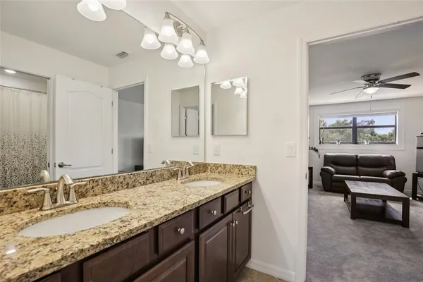 a bathroom with a granite countertop sink and a mirror