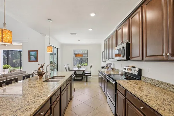 a kitchen with stainless steel appliances granite countertop sink stove top oven and cabinets