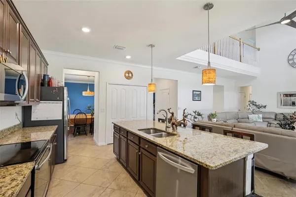 a kitchen with stainless steel appliances granite countertop a sink a stove and a wooden cabinets