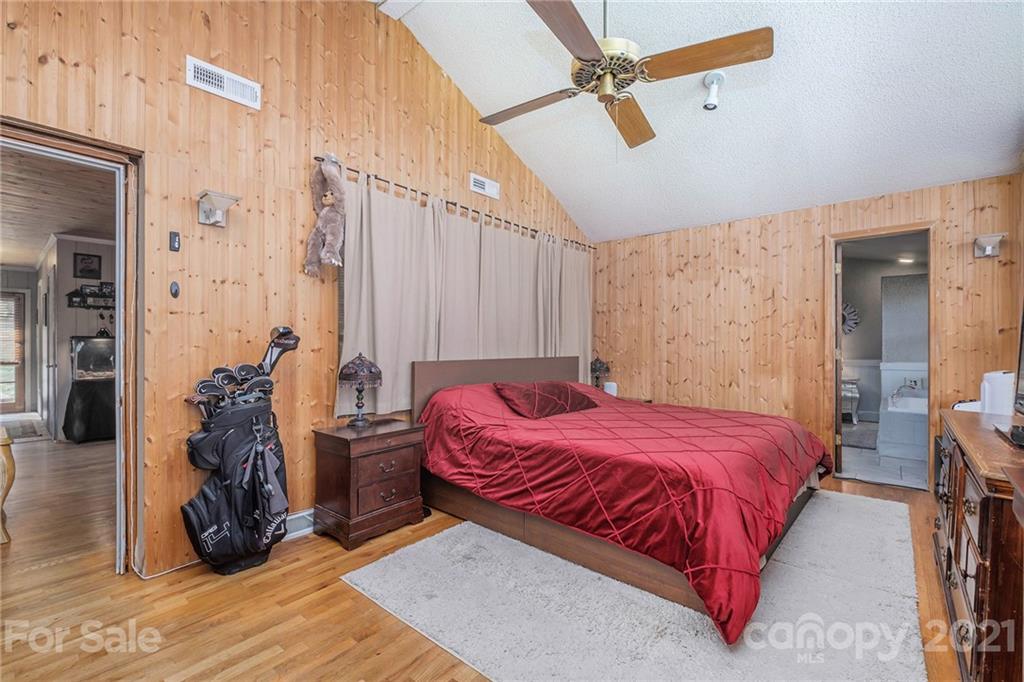 13914 Point Lookout Road Charlotte, NC 28278 - Photo 26 of 41 a bedroom with a bed and a chandelier