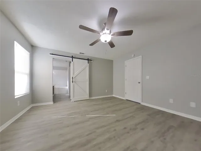 a view of empty room with window and ceiling fan