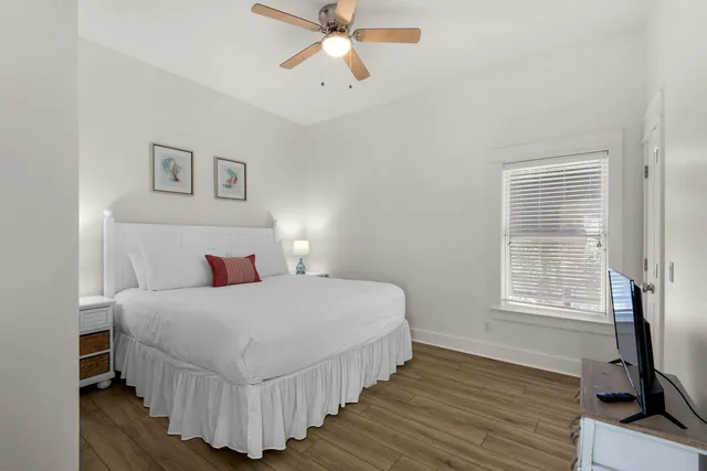 a bedroom with a bed and a flat tv screen on wall