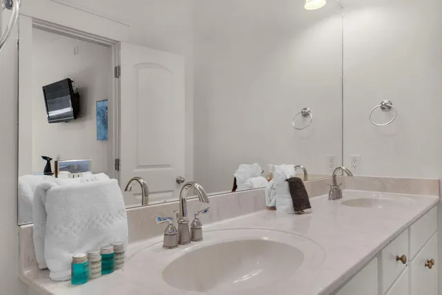 a bedroom with a bed a mirror on dresser and a chandelier