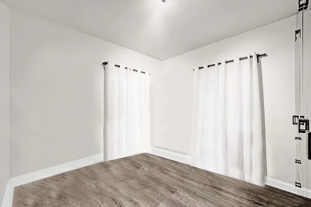 a bedroom with a bed and a lamp on dresser