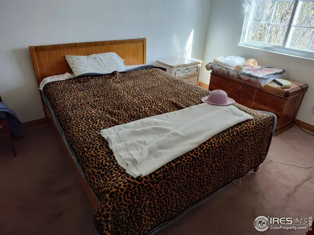 a bed sitting in a bedroom next to a window